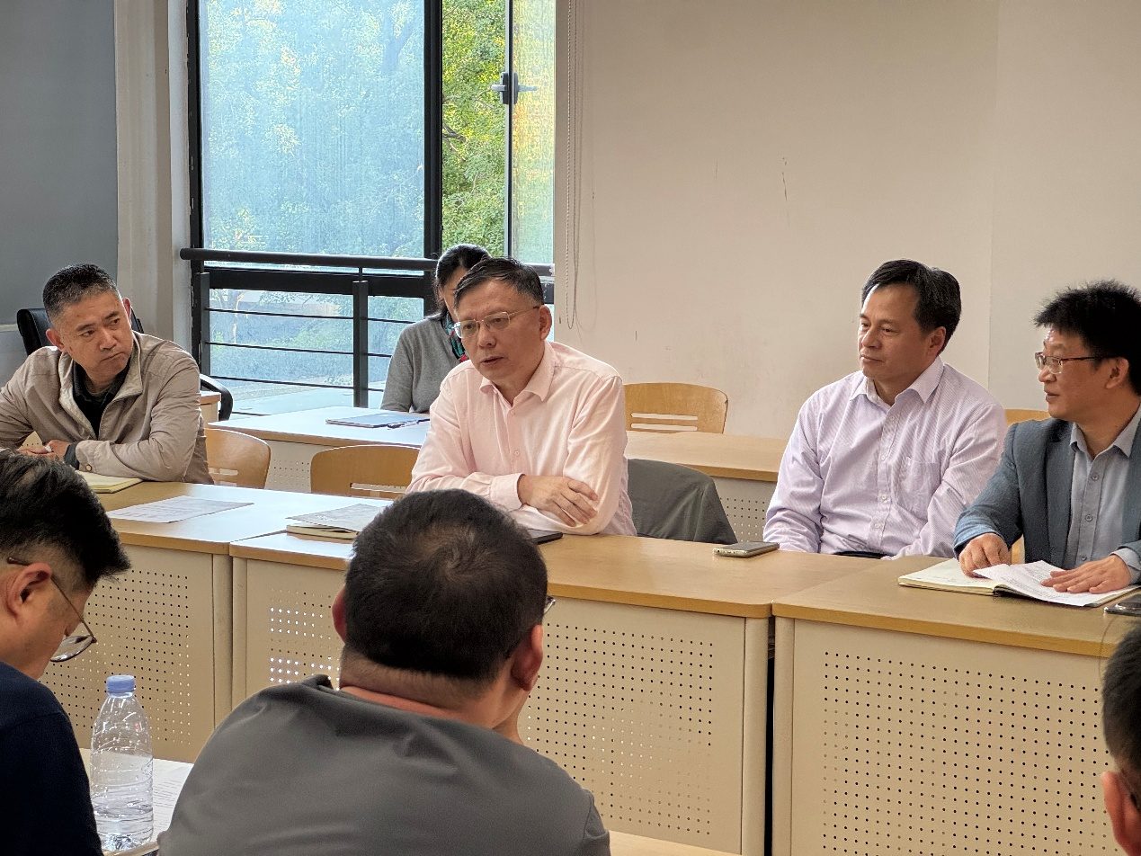 与会者围坐长桌，一位与会者正在发言。